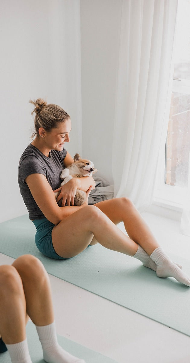 Girl holding a puppy during Puppy Yoga class in Australia with Yogi Paws